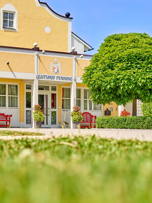Der einladende Eingang des Gutshofs bei Bad Griesbach mit Blumenarrangements und einem gepflegten Vorgarten.