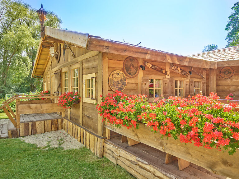 Einladende Holzhütte mit dekorativen Elementen – perfekte Firmenfeier Location in Bayern.