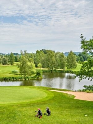 Ein schöner Golfplatz mit grünen Fairways, einem See und dem Zielbereich für den nächsten Golfkurs.