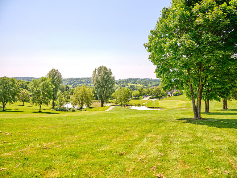 Idyllische Golflandschaft mit sanften Hügeln und Wasserflächen, eine beliebte Kulisse für Golfturniere bei Bad Griesbach.