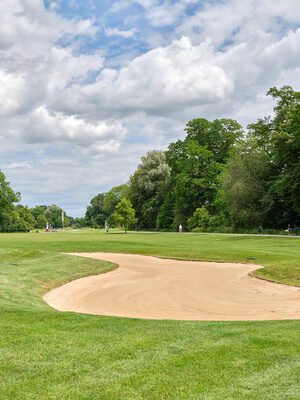 Golfplatz in der Nähe von Bad Griesbach mit weitläufigem Fairway, gepflegtem Rasen und einem Golfcart im Hintergrund.