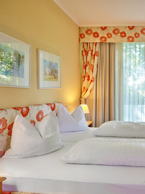 Helles Hotelzimmer mit buntem Design und Balkon.