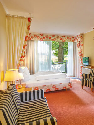 Geräumiges Zimmer mit fröhlichem Design und direktem Zugang zu einem Balkon.