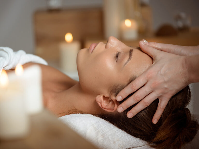 Frau erhält eine entspannende Kopf- und Nackenmassage in einem Wellnesshotel bei Bad Griesbach.