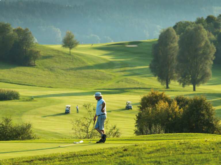 Zwei Menschen spielen Golf auf einem der Golfplätze in der Nähe von Bad Griesbach im Grünen.